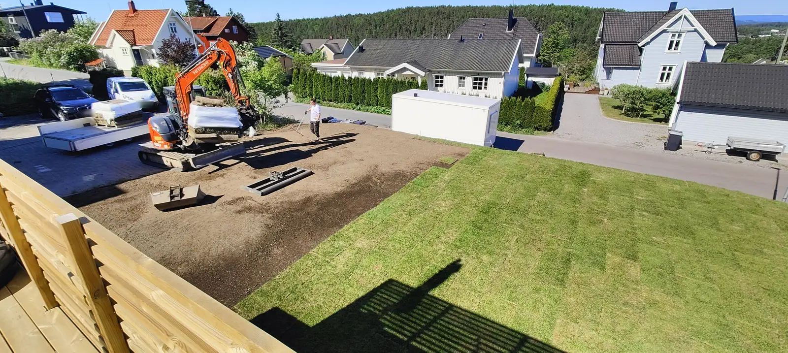 Best Miljø legger ferdigplen – ferdig plen til høyre, planert jord og minigraver til venstre